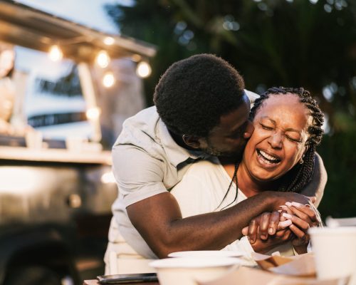 African mother and son having fun together outdoor at food truck restaurant - Love and family lifestyle concept - Focus on mum face