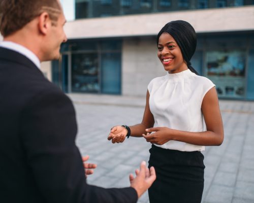 Business woman and businessman, outdoors meeting of partners, partnership negotiations. Successful businesspeople